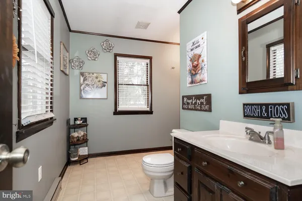 a bathroom with a granite countertop toilet sink and mirror