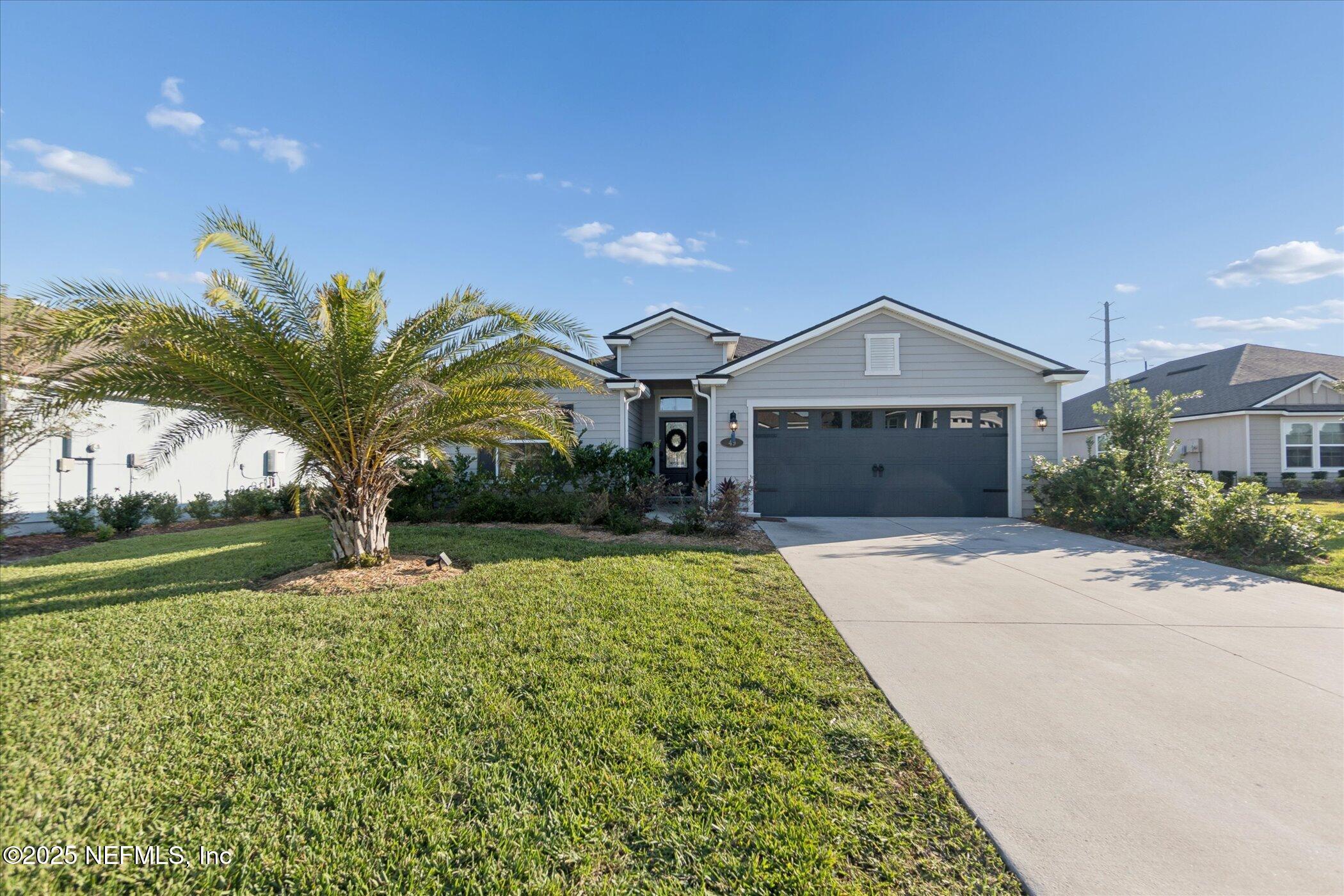 49 Sunberry Way St. Augustine, FL 32092 - Photo 2 of 30 a front view of a house with a yard and garage