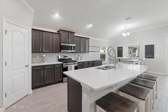 a kitchen with kitchen island a sink a stove a refrigerator cabinets and a counter top space