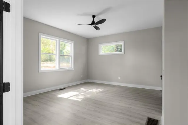 a view of a big room with wooden floor closet and windows