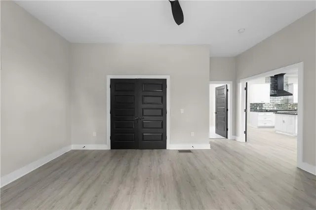 a view of an empty room with a window and a ceiling fan