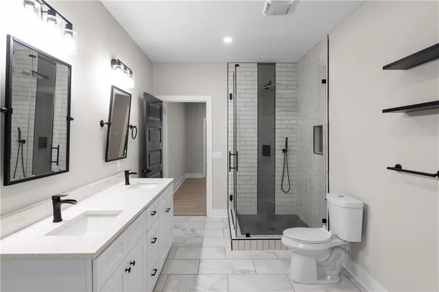 a bathroom with a glass shower door sink and mirror