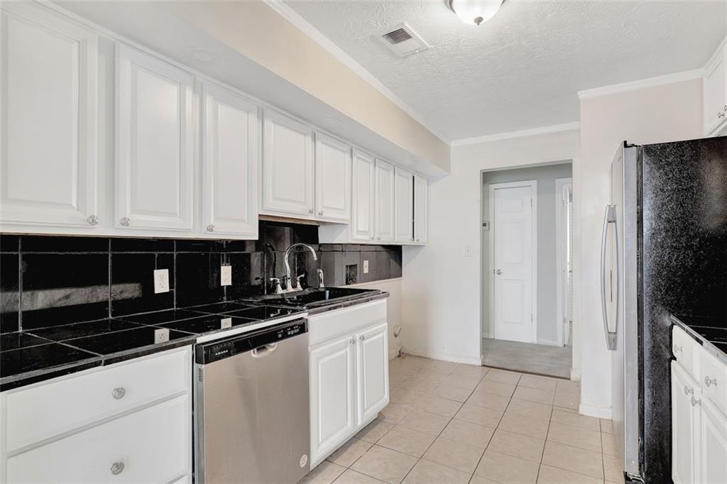 2390 Lawrenceville Highway, Unit K Decatur, GA 30033 - Photo 11 of 22 a kitchen with stainless steel appliances granite countertop a stove a sink and a refrigerator