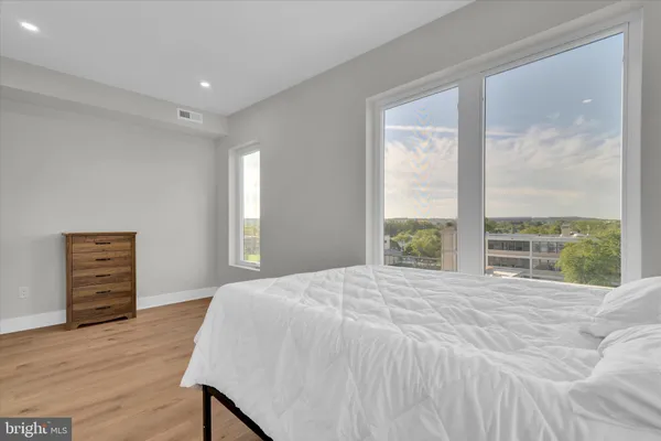 a bed sitting in a spacious bedroom next to a window