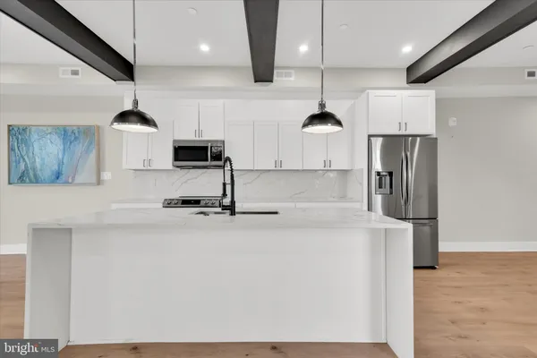 a kitchen with stainless steel appliances granite countertop a sink a stove and a refrigerator