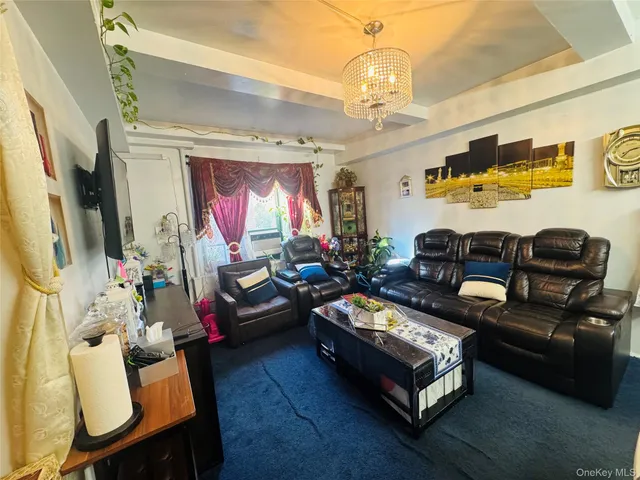 a living room with furniture a chandelier and a flat screen tv