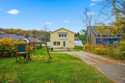 a view of a house with a yard and sitting area