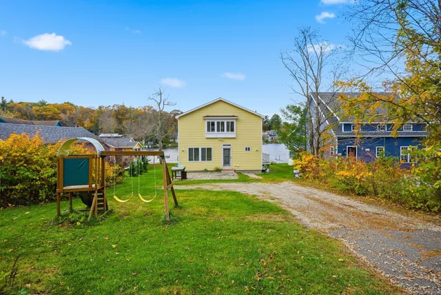 a view of a house with a yard and sitting area