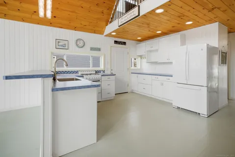 a kitchen with white cabinets and white appliances