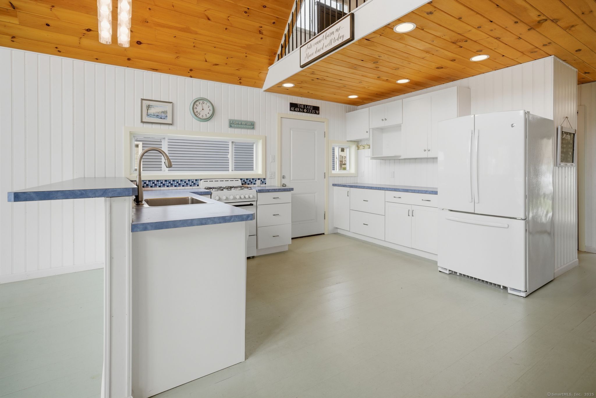 136 Sandy Beach Road Goshen, CT 06756 - Photo 6 of 26 a kitchen with white cabinets and white appliances