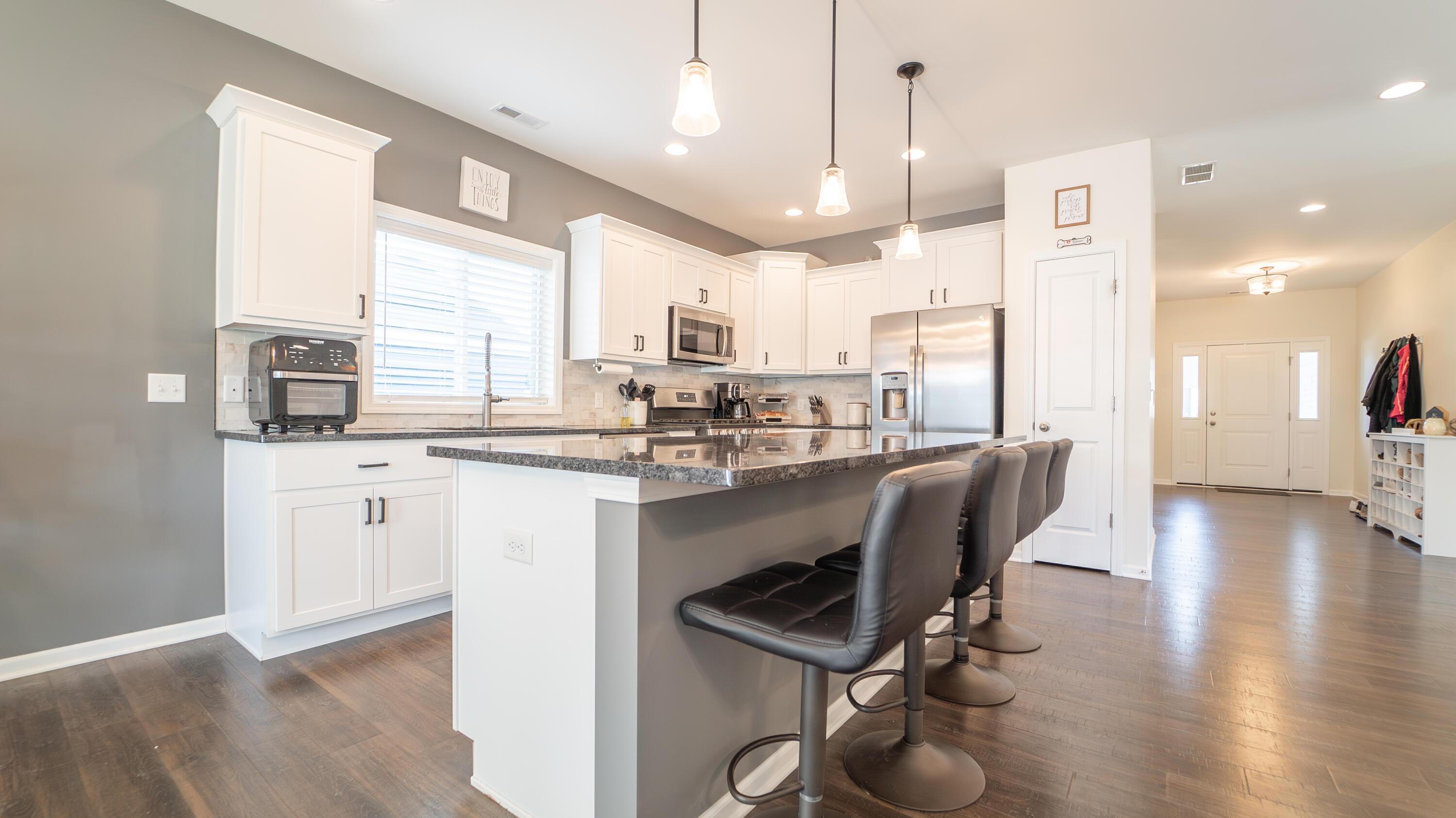 538 Emerald Drive Chesterton, IN 46304 - Photo 9 of 25 a kitchen with stainless steel appliances granite countertop a stove top oven a sink dishwasher a dining table and chairs with wooden floor