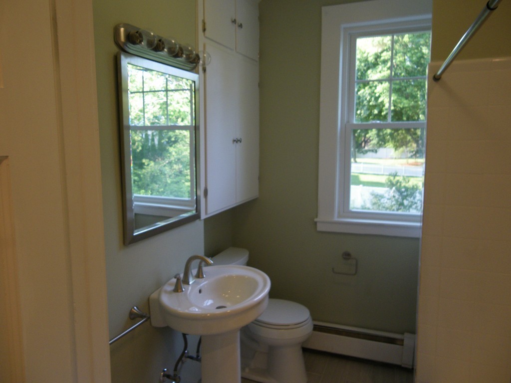 63 Oak Street, Unit B Needham, MA 02492 - Photo 7 of 8 a bathroom with a sink a mirror and a toilet