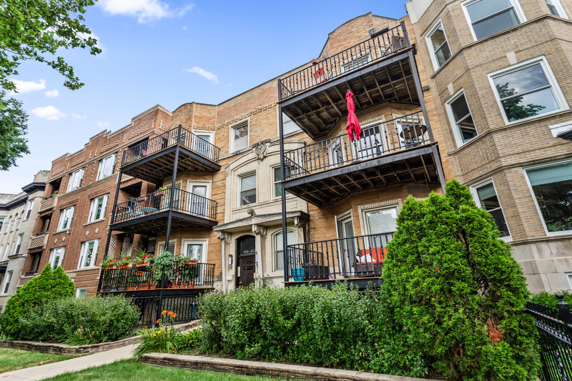 a front view of a multi story residential apartment building with yard