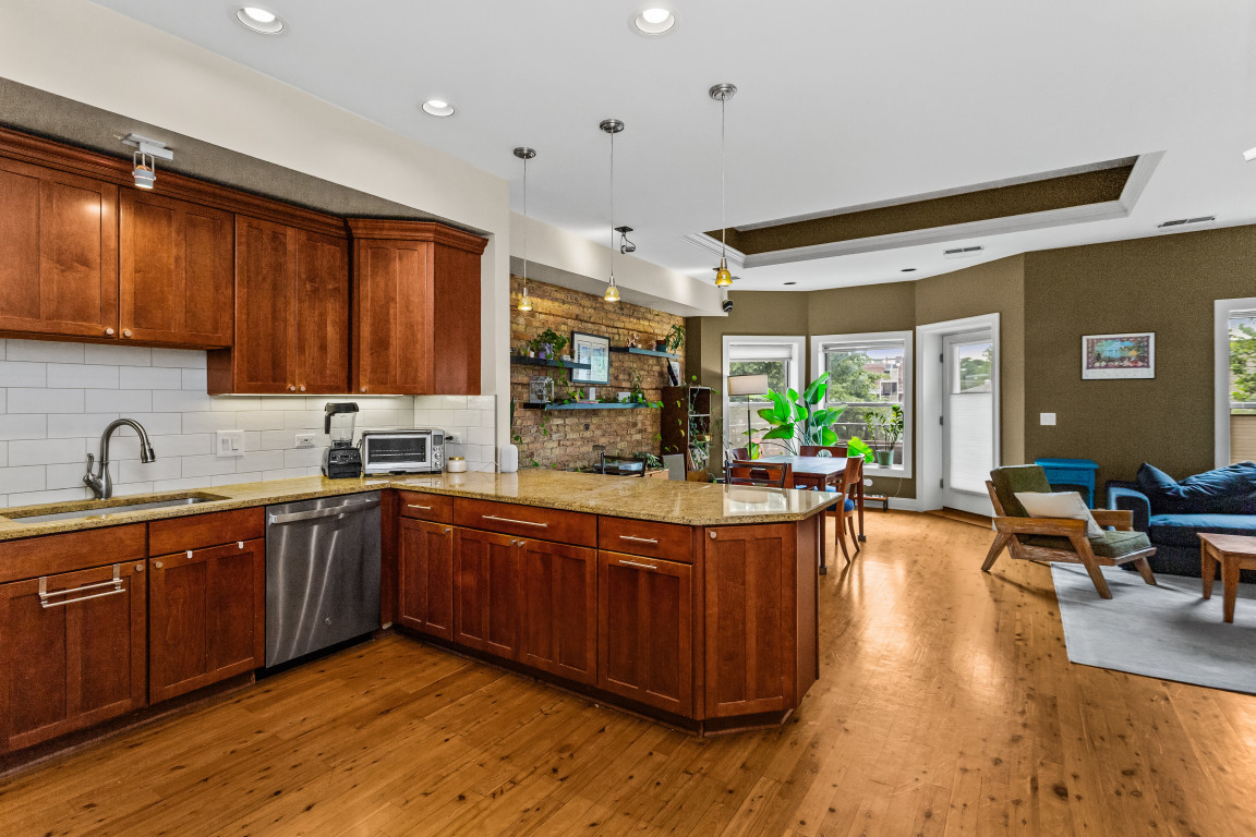 4635 North Malden Street, Unit 3S Chicago, IL 60640 - Photo 7 of 20 a large kitchen with stainless steel appliances wooden floors and a view of living room