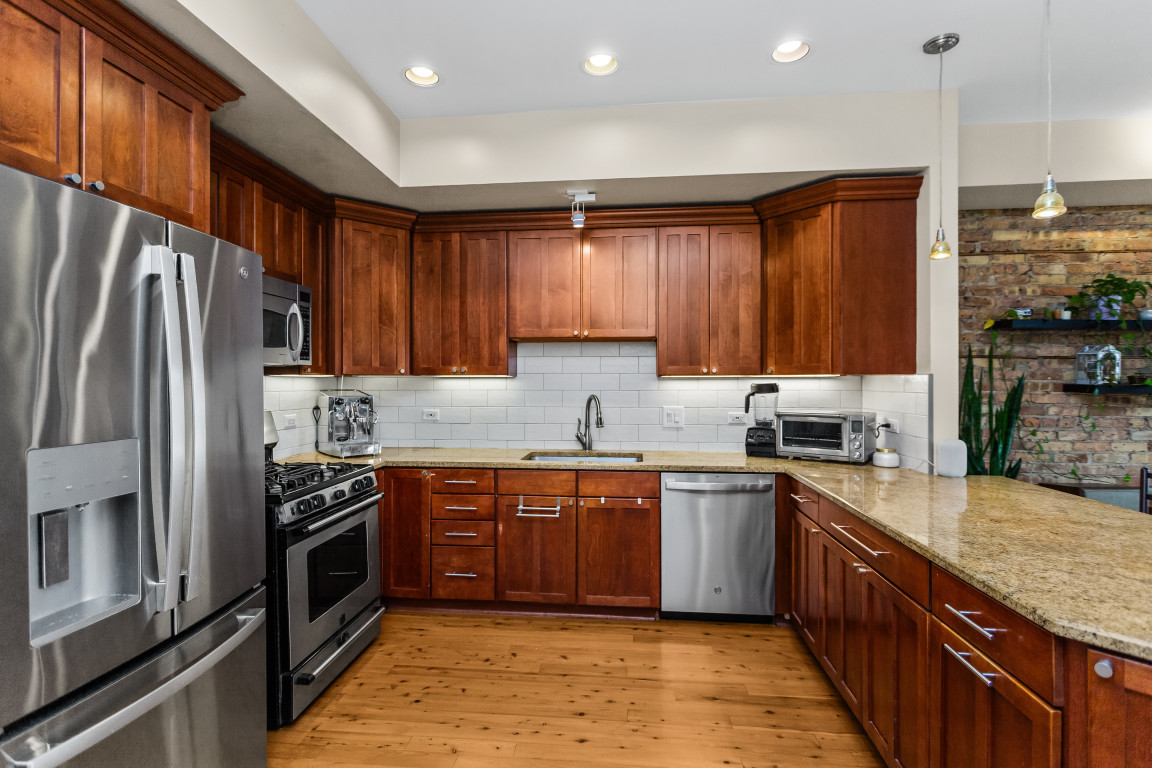 4635 North Malden Street, Unit 3S Chicago, IL 60640 - Photo 8 of 20 a kitchen with stainless steel appliances granite countertop a stove top oven a sink dishwasher a refrigerator and a oven with wooden floor