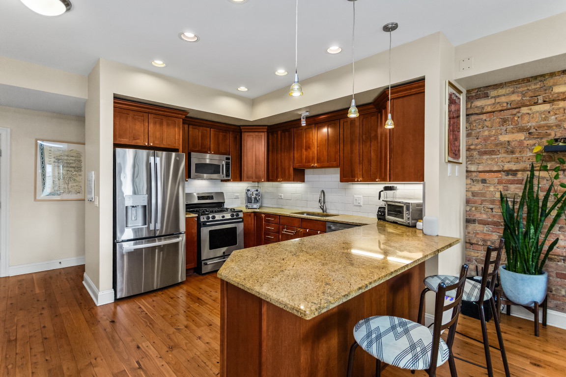4635 North Malden Street, Unit 3S Chicago, IL 60640 - Photo 9 of 20 a kitchen with granite countertop stainless steel appliances a stove refrigerator and cabinets