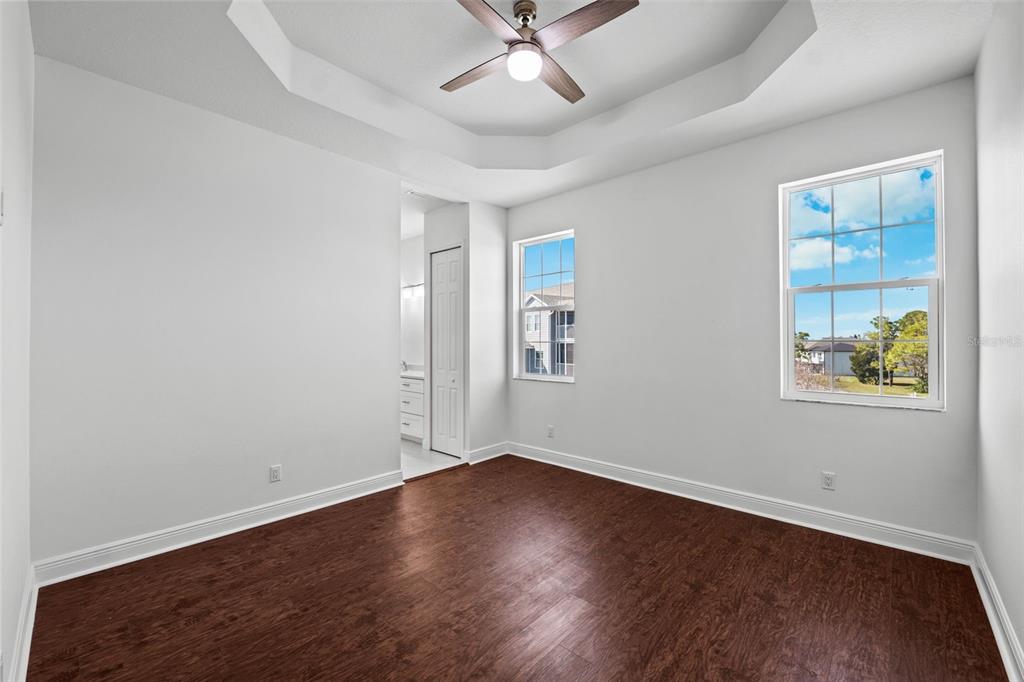 5732 Biscayne Court, Unit 1 New Port Richey, FL 34652 - Photo 14 of 48 an empty room with wooden floor chandelier fan and windows