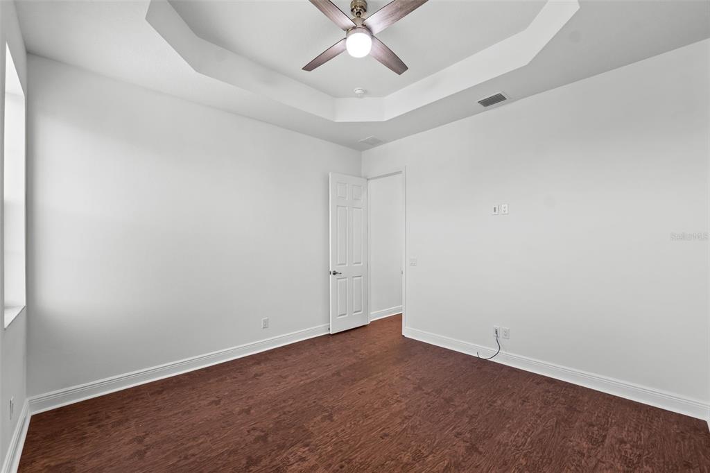 5732 Biscayne Court, Unit 1 New Port Richey, FL 34652 - Photo 15 of 48 an empty room with a ceiling fan and wooden floor