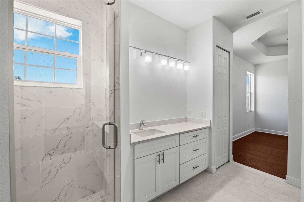 5732 Biscayne Court, Unit 1 New Port Richey, FL 34652 - Photo 17 of 48 a bathroom with a granite countertop sink a mirror and a shower