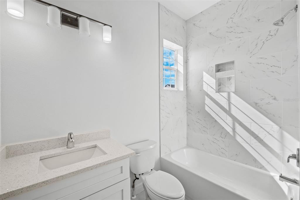 5732 Biscayne Court, Unit 1 New Port Richey, FL 34652 - Photo 21 of 48 a bathroom with a sink toilet and shower