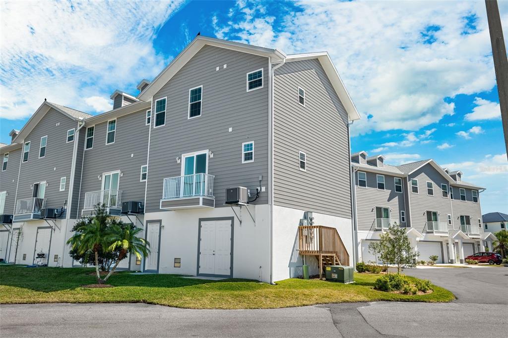5732 Biscayne Court, Unit 1 New Port Richey, FL 34652 - Photo 48 of 48 a view of a white house with a yard and plants
