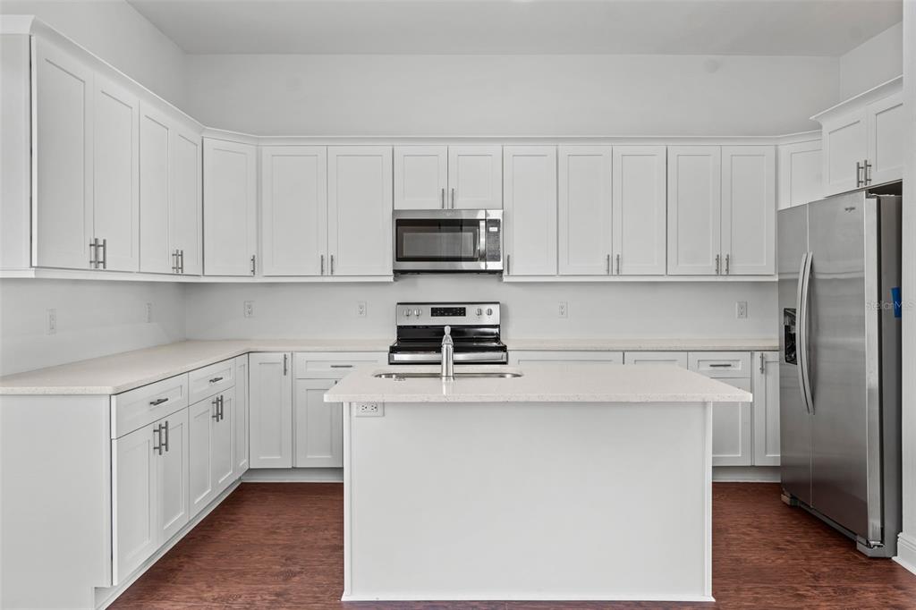 5732 Biscayne Court, Unit 1 New Port Richey, FL 34652 - Photo 9 of 48 a kitchen with stainless steel appliances white cabinets and a refrigerator