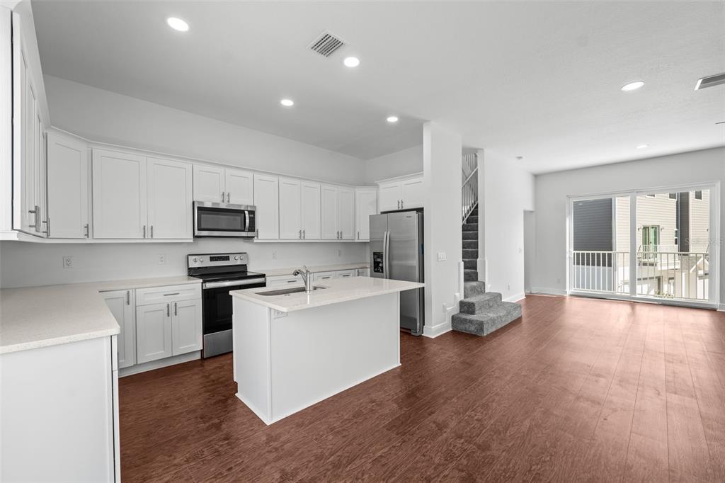 5732 Biscayne Court, Unit 1 New Port Richey, FL 34652 - Photo 10 of 48 a kitchen with stainless steel appliances a refrigerator stove and white cabinets