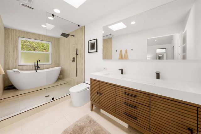 a white tub sitting next to a bathroom sink