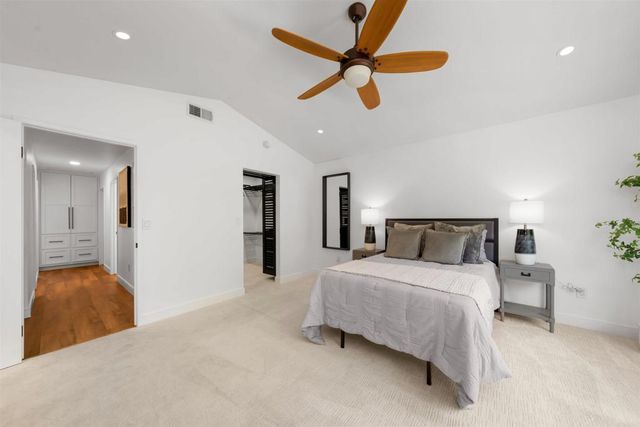 a spacious bedroom with a bed a couch and a large window