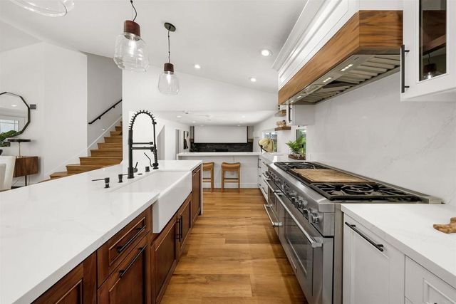 a kitchen with kitchen island a sink stove and cabinets