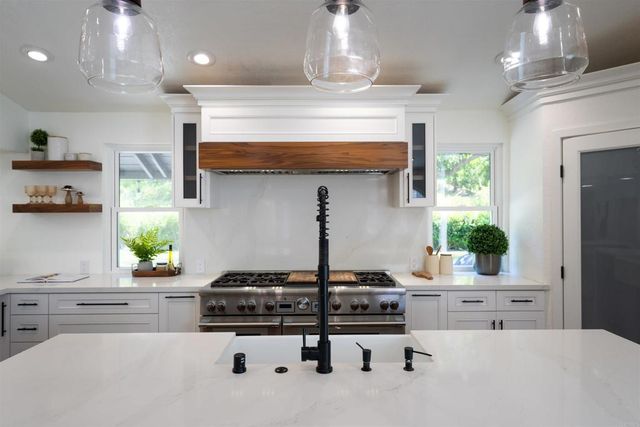 a kitchen with stainless steel appliances kitchen island sink stove and cabinets
