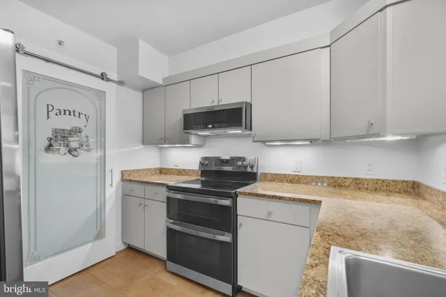 a kitchen with stainless steel appliances granite countertop a stove a sink and a microwave
