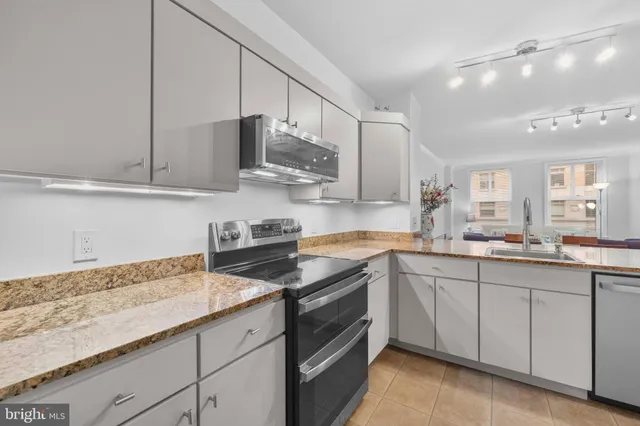 a kitchen with stainless steel appliances granite countertop a sink stove and cabinets