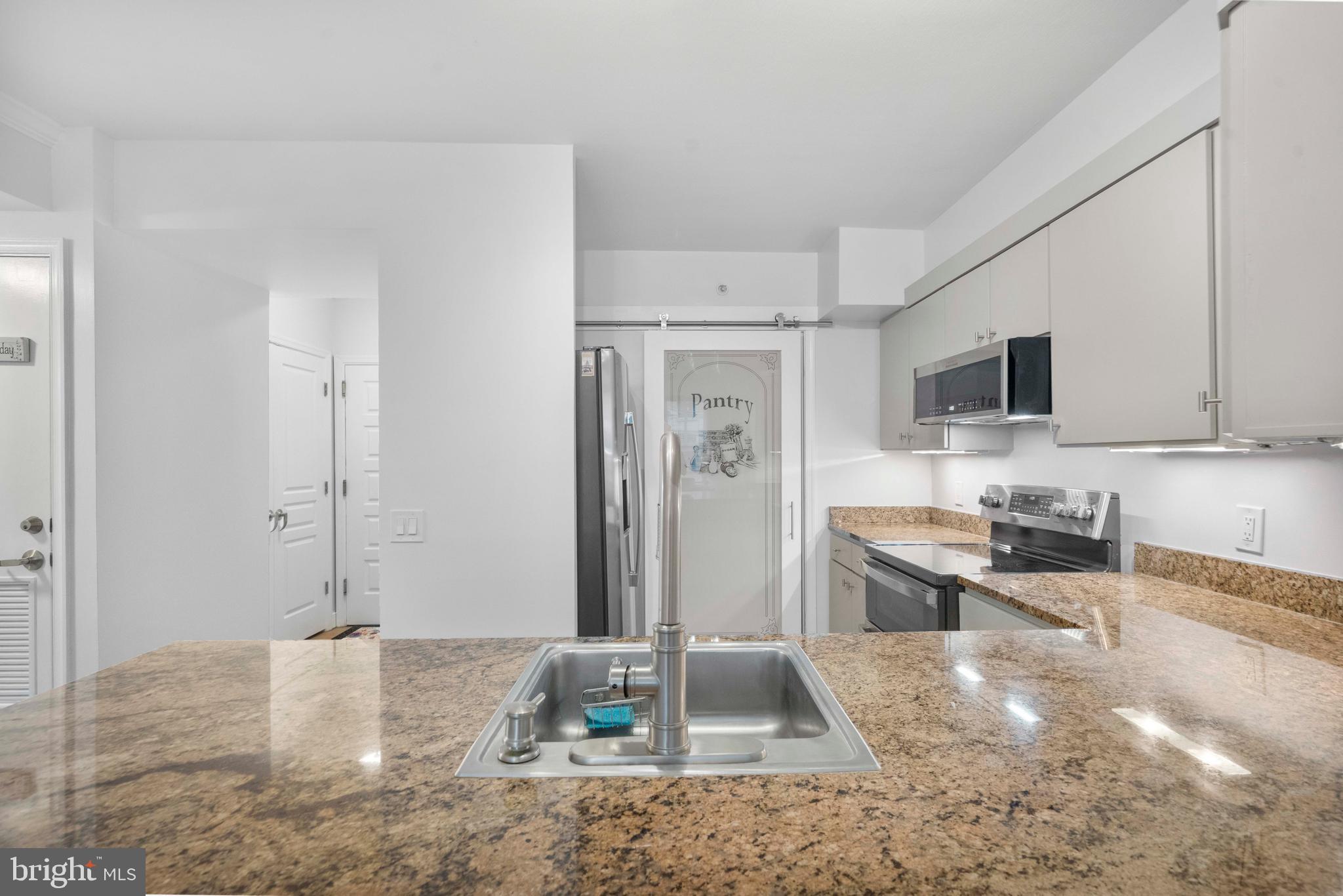 616 E Street Northwest, Unit 522 Washington, DC 20004 - Photo 15 of 43 a kitchen with stainless steel appliances granite countertop a sink stove and refrigerator