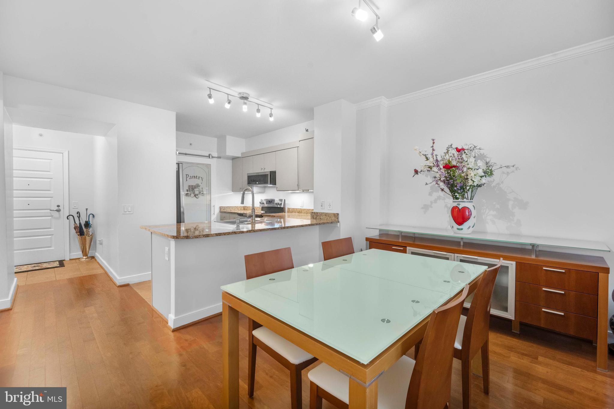 616 E Street Northwest, Unit 522 Washington, DC 20004 - Photo 9 of 43 a kitchen with stainless steel appliances cabinets table and chairs