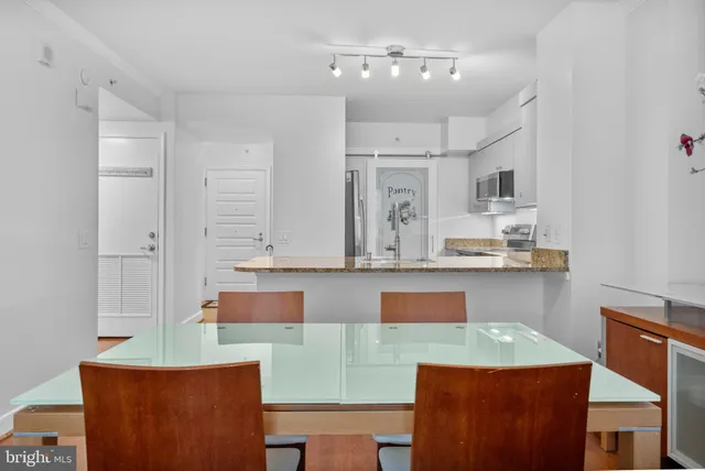 a room with kitchen island stainless steel appliances furniture cabinets and a counter top space