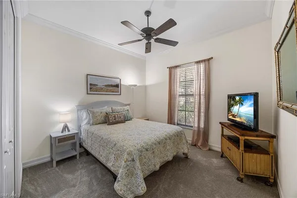 a spacious bedroom with a bed and a chandelier