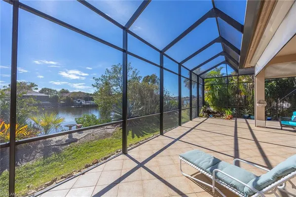 a view of a patio with table and chairs potted plants with floor to ceiling window and potted plants