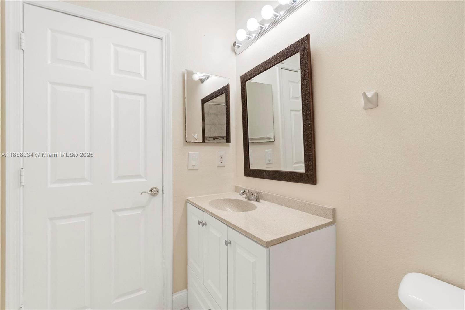 2508 Southwest 85th Terrace, Unit 105 Miramar, FL 33025 - Photo 23 of 27 a bathroom with a sink a toilet and mirror