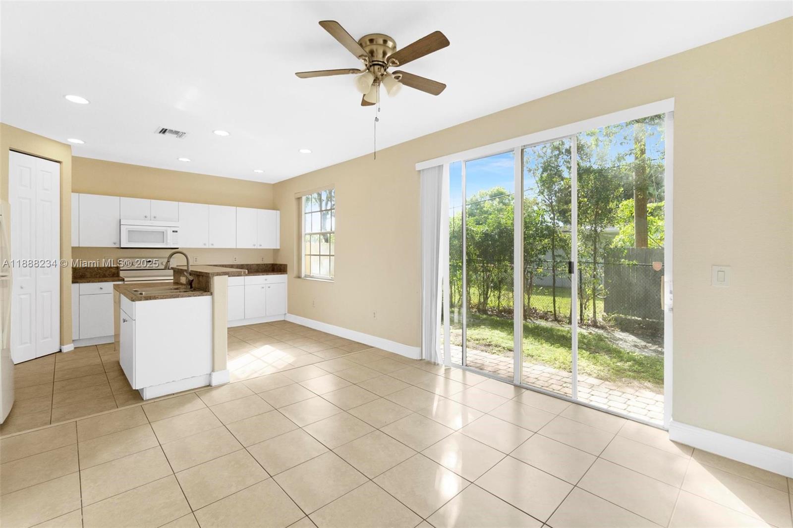 2508 Southwest 85th Terrace, Unit 105 Miramar, FL 33025 - Photo 9 of 27 a kitchen with stainless steel appliances granite countertop a stove a refrigerator a sink a microwave oven and a dining table with wooden cabinet