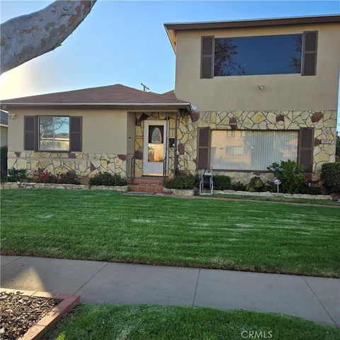 a front view of a house with a garden and yard