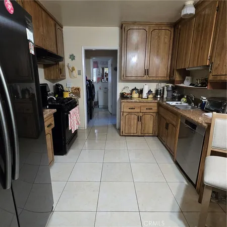 a kitchen with stainless steel appliances granite countertop a sink a stove and a refrigerator