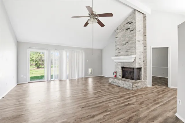 wooden floor fireplace and windows in an empty room