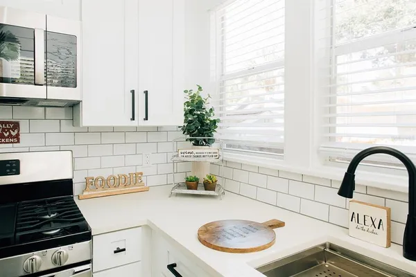 a kitchen with a stove and a white wooden cabinets