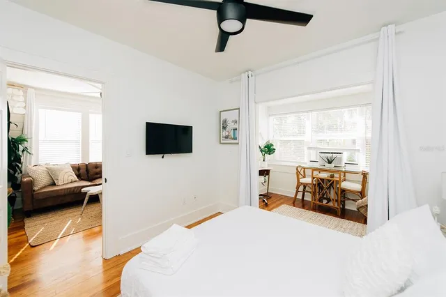 a bedroom with a bed a flat screen tv and a couch