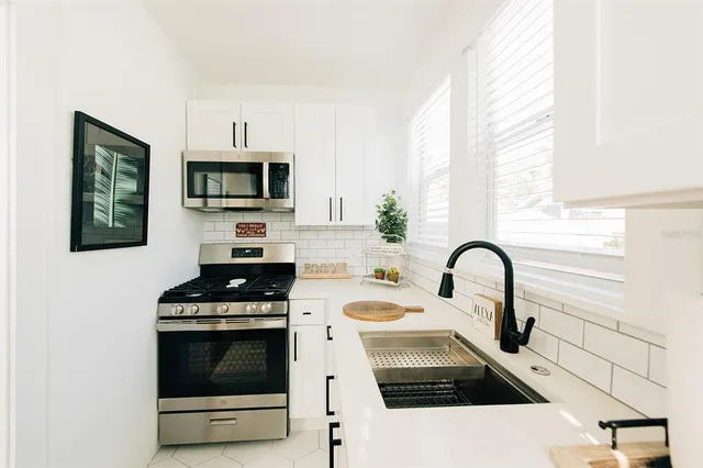a kitchen with stainless steel appliances a stove a sink and a microwave