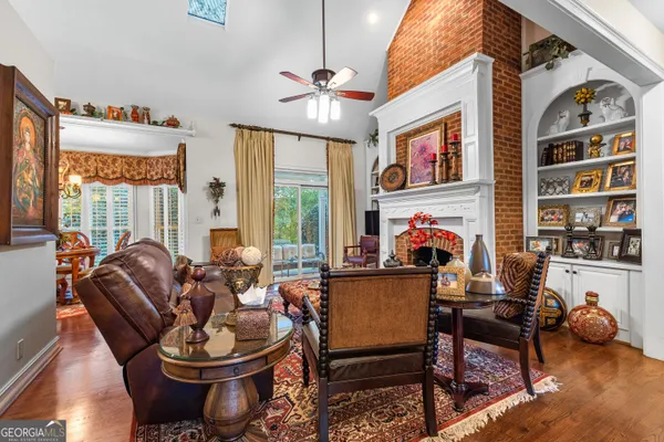 a kitchen with stainless steel appliances granite countertop a refrigerator a sink dishwasher a stove and a dining table with wooden floor