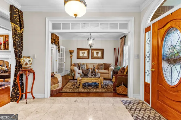 a dining room with furniture a chandelier and wooden floor