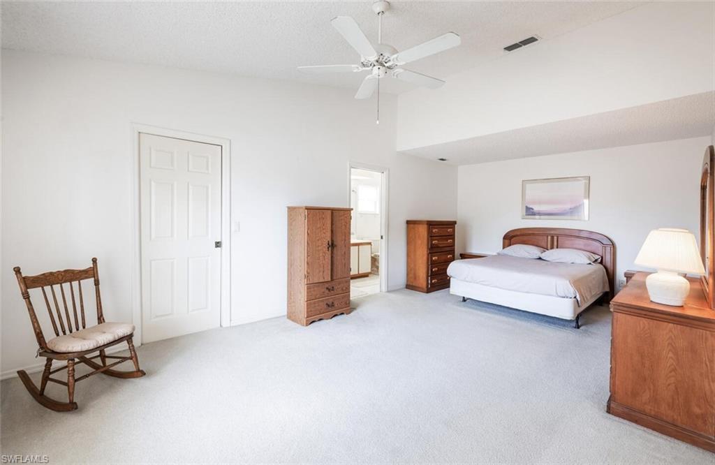 814 Charlemagne Boulevard Naples, FL 34112 - Photo 14 of 33 a bedroom with a bed and a chair