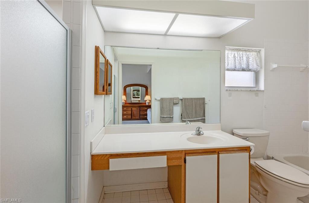 814 Charlemagne Boulevard Naples, FL 34112 - Photo 17 of 33 a bathroom with a sink and a mirror